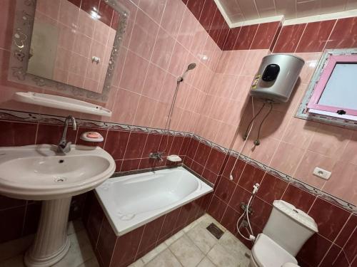 a bathroom with a sink and a tub and a toilet at Apartment 18 Maspero in Alexandria