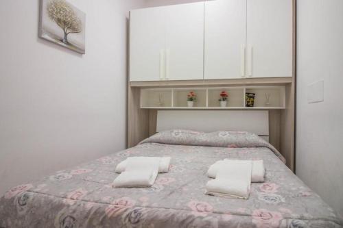 a bedroom with a large bed with white cabinets at Saint Simplicio House in Olbia
