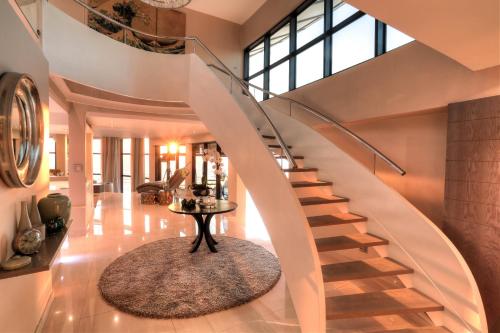 a spiral staircase in a home with a table at Ocean View Penthouse in Strand