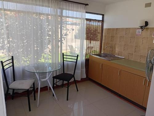 a kitchen with a table and chairs and a sink at Las Cabañas del Francés in Vallenar