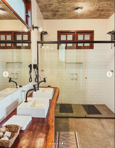 a bathroom with two sinks and a shower at Pousada Caminho Das Cachoeiras in Sao Jorge