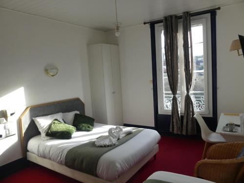 a bedroom with a bed with a cat statue on it at Le Renaissance in Montdidier
