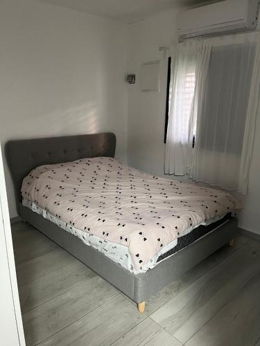 a bed sitting in a bedroom next to a window at הבית של גיא בנאי in Beer Sheva