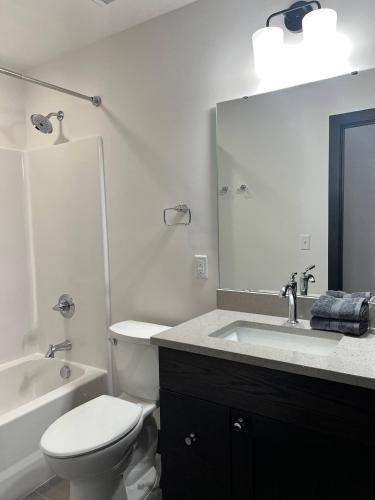 a bathroom with a toilet and a sink and a mirror at Brick & Bed Riverfront Lofts, T 410 in Saint Louis