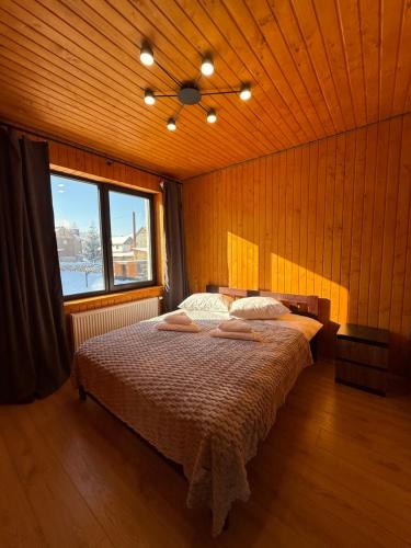 a bedroom with a bed and a large window at Fangorn in Lazeshchyna