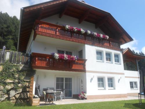 a house with a balcony with flowers on it at Apartment Wohnung Michaela in Flattach by Interhome in Flattach