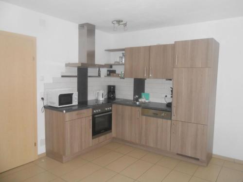 a kitchen with wooden cabinets and a microwave at Apartment Wohnung Michaela in Flattach by Interhome in Flattach