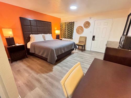 a hotel room with a bed and a table at The Crest Motel in Corona