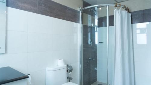 a bathroom with a shower and a toilet at The Avenue Hotel & Suites in Chittagong