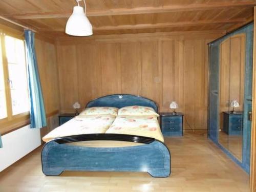a bedroom with a blue bed in a room at Apartment Gurtendörfli by Interhome in Wabern