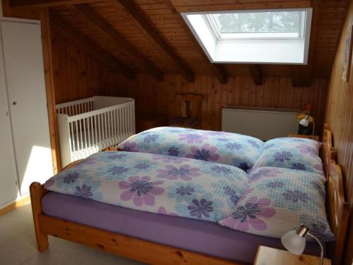 a bedroom with a bed with pillows and a window at Apartment Wohnung Rustique by Interhome in Chevenez