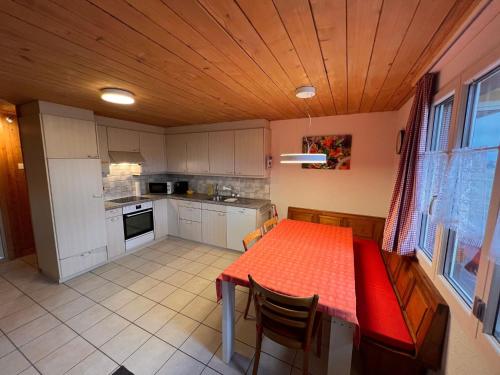 a kitchen with a table with a red table cloth at Apartment Chalet Hulda by Interhome in Heimenschwand