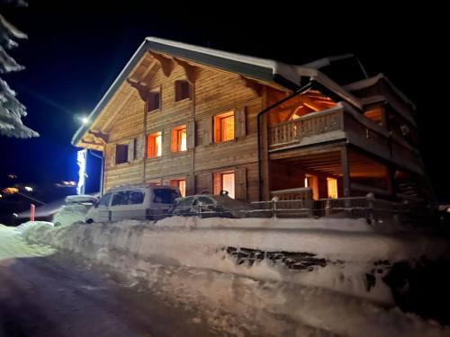 a wooden house in the snow at night at Apartment Peak App- Morgins by Interhome in Morgins