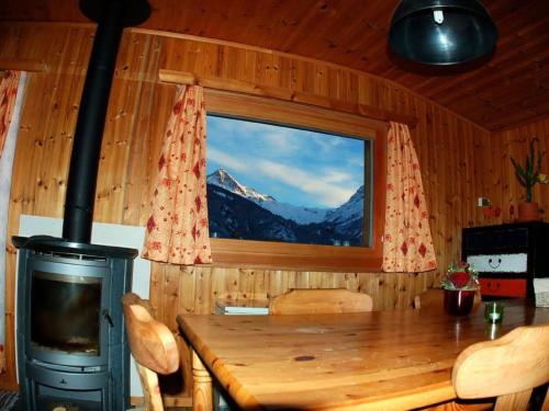 a room with a table and a window with a mountain view at Apartment Base Camp Evolène by Interhome in Evolène