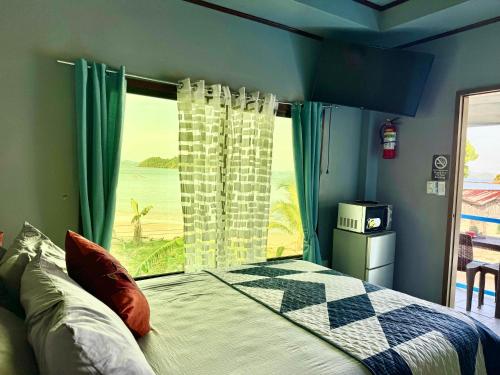 a bedroom with a bed and a large window at Seaside Blue Inn in San Vicente