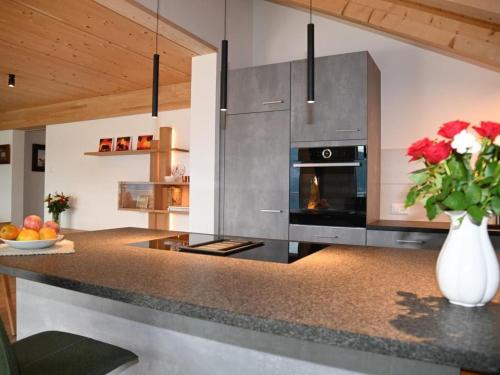 a kitchen with a counter with a vase of flowers at Apartment Panorama-Beatenberg by Interhome in Beatenberg