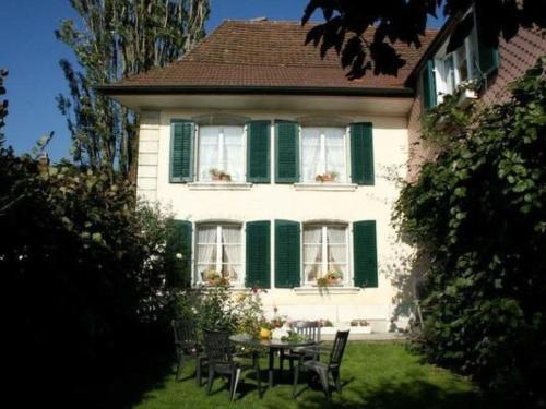 a house with green shutters and a table and chairs at Apartment Stöckli by Interhome in Attiswil