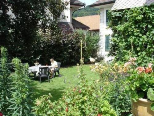 two people sitting at a table in a garden at Apartment Stöckli by Interhome in Attiswil
