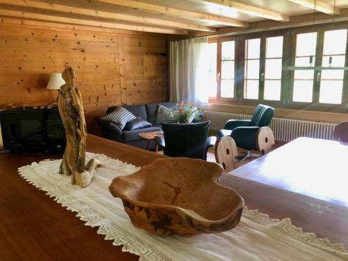 a room with a bed and a statue on a table at Apartment Chalet Ried by Interhome in Diemtigen
