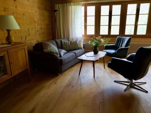 a living room with a couch and two chairs and a table at Apartment Chalet Ried by Interhome in Diemtigen