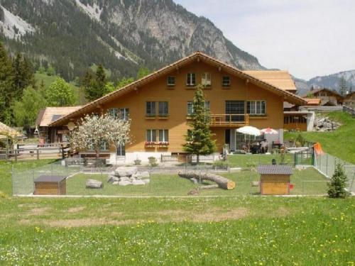 a house with a playground in front of a mountain at Apartment Appartement Eggmatte by Interhome in Grimmialp