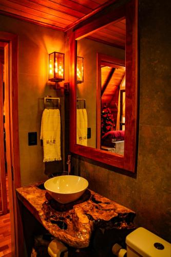 a bathroom with a sink and a mirror at Chalet Relaggio in Encantado