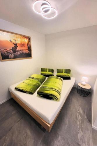 a bedroom with a large white bed with green pillows at Apartment Chalet Lilo Studio by Interhome in Beatenberg