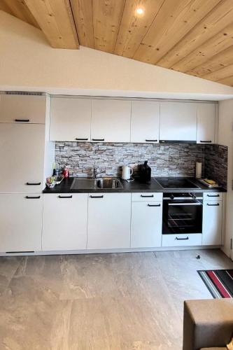 a kitchen with white cabinets and a sink at Apartment Chalet Lilo Studio by Interhome in Beatenberg