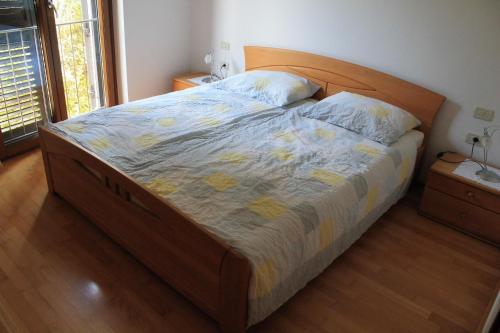 łóżko z drewnianym zagłówkiem w sypialni w obiekcie Apartment Felicia w Portorožu