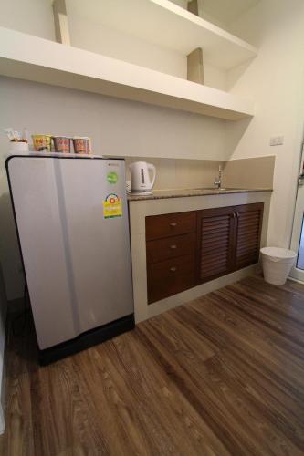 a kitchen with a refrigerator and a wooden floor at At Residence Suvarnabhumi Hotel in Lat Krabang