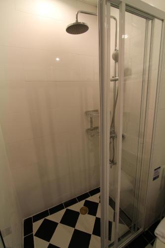 a bathroom with a shower with a checkered floor at At Residence Suvarnabhumi Hotel in Lat Krabang
