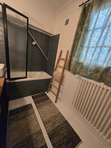 a bathroom with a shower and a bath tub and a chair at La maison bleue avec une grande piscine chauffée in Bozouls