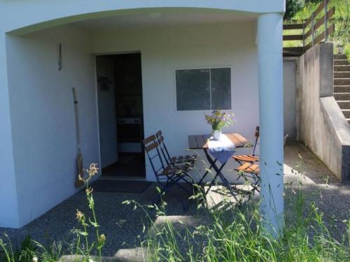 a patio with two chairs and a table in a house at Apartment Huusli by Interhome in Axalp