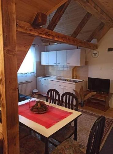 a kitchen and dining room with a table and chairs at Vikendica SANA Vlašić in Šišava