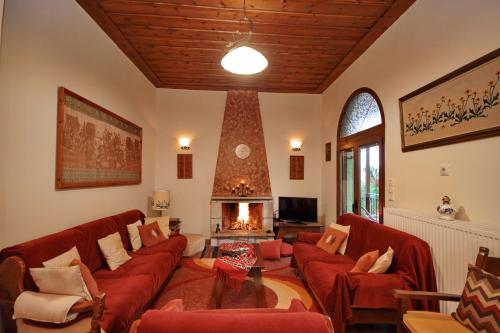 a living room with red couches and a fireplace at Valtessiniko Studios in Valtessiniko