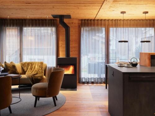 a kitchen with a living room with a fireplace at Apartment My Chalet by Interhome in Meiringen