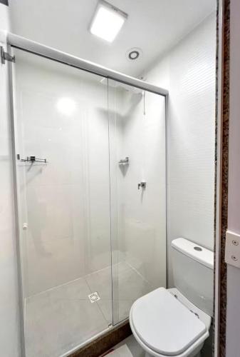 a bathroom with a glass shower with a toilet at Nas Nuvens em Itaparica in Vila Velha