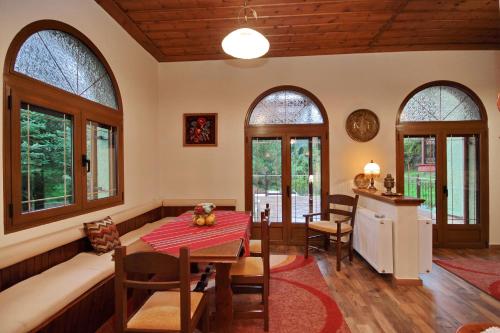 a dining room with a table and some windows at Valtessiniko Studios in Valtessiniko