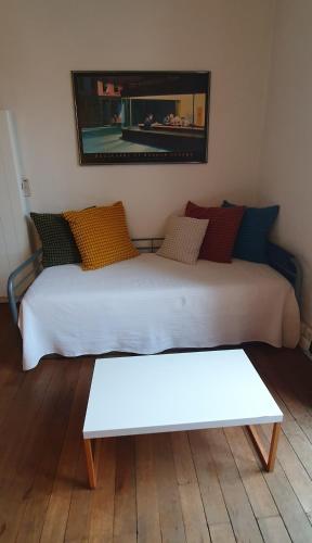a white bed with a bench in a room at Le Denfert, 40m2 avec vue in Grenoble