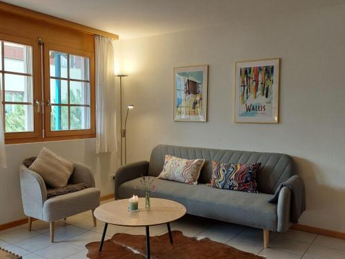 a living room with a couch and a table at Apartment Aspa EG by Interhome in Bellwald