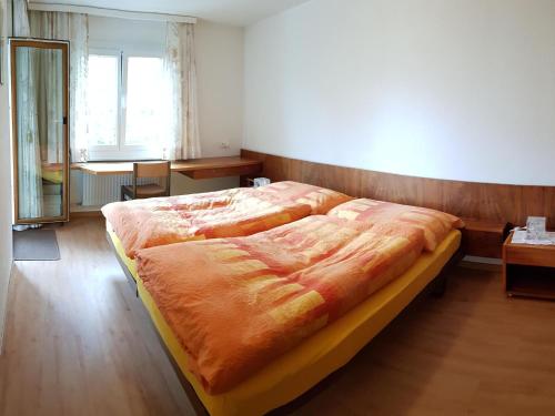 a large bed in a bedroom with a wooden wall at Apartment Royal 22 nahe Klinik- Burgerbad- Einkaufszentrum by Interhome in Leukerbad