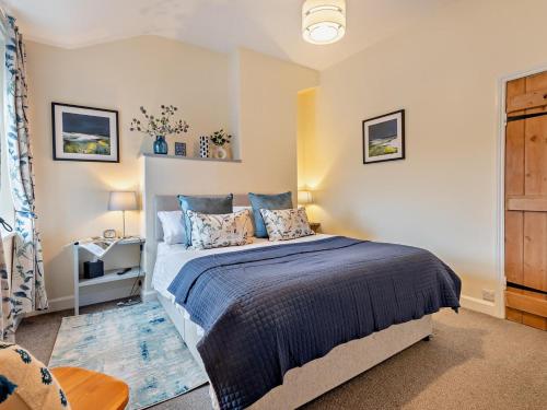 a bedroom with a large bed with blue pillows at 2 Bed in Keswick oc-sz006 in Keswick