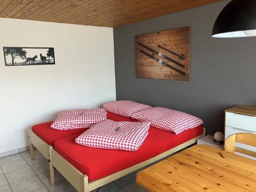 a room with a bed with red and white pillows at Apartment Anneliese Schaad Studio by Interhome in Hasliberg Wasserwendi