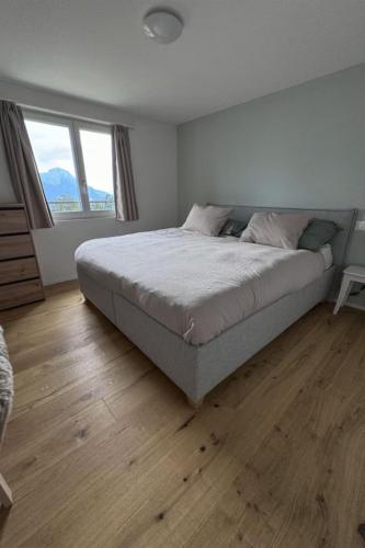 a bedroom with a large bed and a wooden floor at Apartment Sunnehöckli by Interhome in Hasliberg