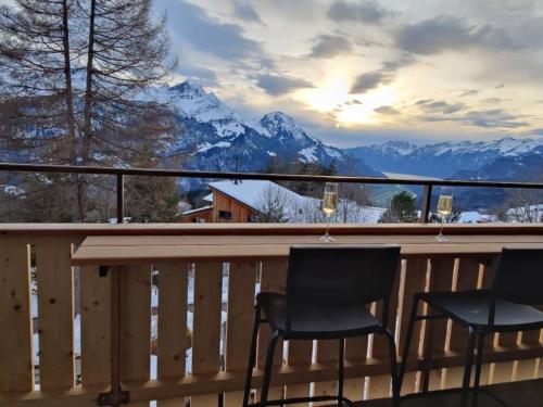 two chairs on a balcony with a view of mountains at Apartment Sunnehöckli by Interhome in Hasliberg