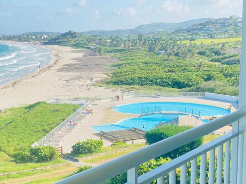 a view of the beach from the balcony of a resort at Excellence Suites Orient Beach Oceanview King-Size Beach Pool Parking in Cul de Sac