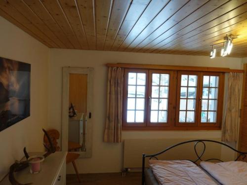 a bedroom with a bed and a wooden ceiling at Apartment Haus Brog by Interhome in Rohrmatten