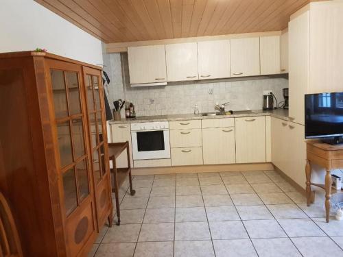 a kitchen with white cabinets and a table and a microwave at Apartment Haus Brog by Interhome in Rohrmatten