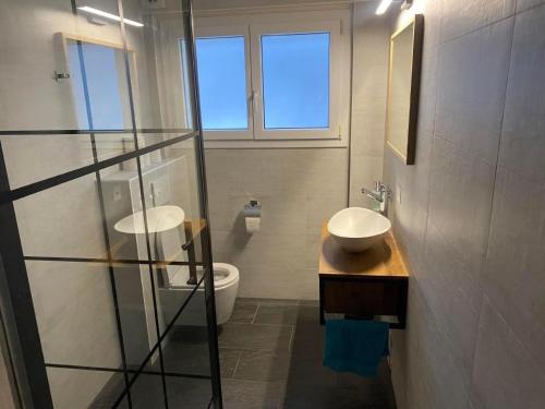 a bathroom with two sinks and a toilet at Apartment Spring Inn Studio by Interhome in Rohrmatten
