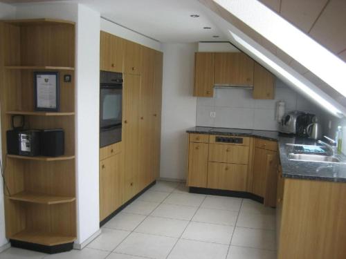 a kitchen with wooden cabinets and a sink at Apartment Gmünde by Interhome in Schüpfheim